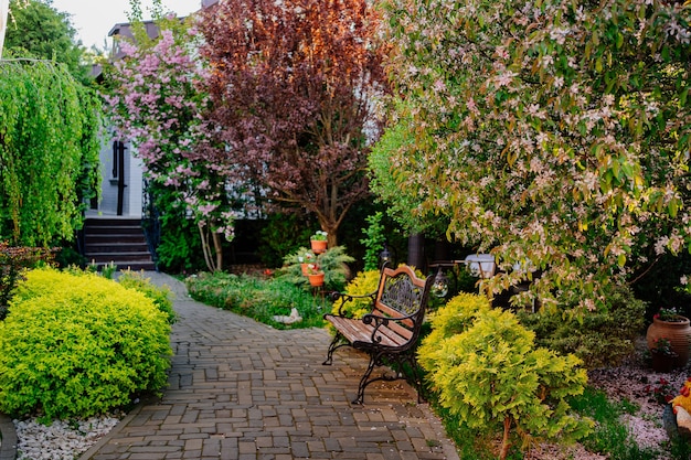 Banc sur le trottoir dans le jardin ou le parc. Aménagement paysager. promenades dans la nature. vacances, méditation et paix. Jardinier et paysagiste.