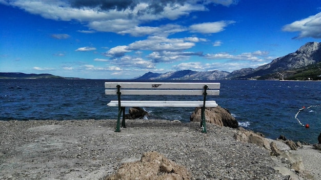 Un banc vide sur le rivage contre le ciel
