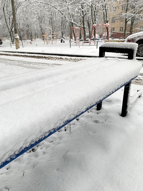 Le banc de la ville est abondamment recouvert de neige