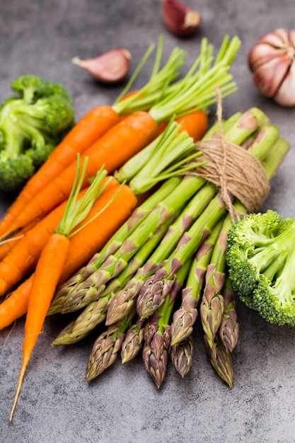 Banches d'asperges vertes fraîches et légumes sur fond de bois, vue du dessus