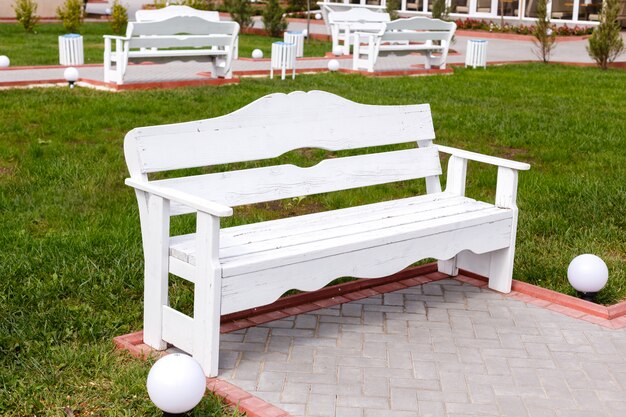 Bancs vides en bois blancs dans le parc de la ville.