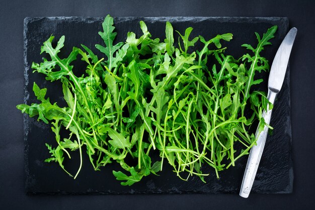 Bande de roquette fraîche sur un tableau noir en ardoise sur une surface sombre