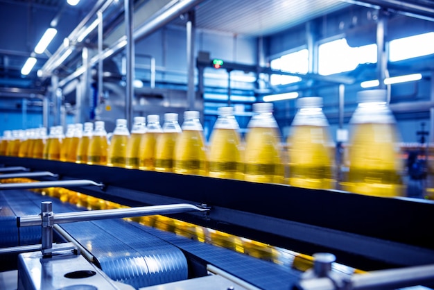 Bande transporteuse avec bouteilles de jus ou d'eau dans une usine de boissons moderne