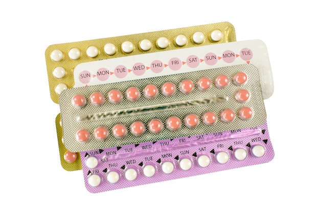 Bandes de pilules contraceptives orales sur fond blanc.