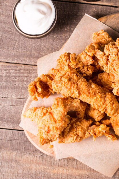 Photo des bandes de poitrine de poulet frites et croquantes avec de la sauce