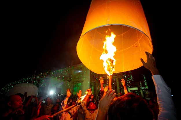 Bangladesh 13 octobre 2019 Un moine bouddhiste avec ses disciples essayant de faire voler une lanterne en papier au temple Ujani Para Buddhist à Bandarban Bangladesh