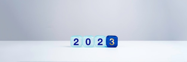 Bannière d'arrière-plan de bonne année 2023 Deux mille numéros de vingt-trois ans sur des blocs de cube bleu isolés sur fond blanc avec espace de copie Bienvenue joyeux Noël et bonne année en 2023