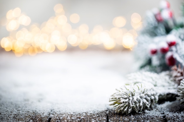 Bannière avec des décorations de noël sur la neige avec des branches de sapin et des lumières de noël hiver