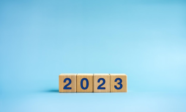 Bannière de fond de bonne année 2023 Deux mille numéros de vingt-trois ans sur des blocs de cube en bois isolés sur fond bleu avec espace de copie Bienvenue joyeux Noël et bonne année en 2023