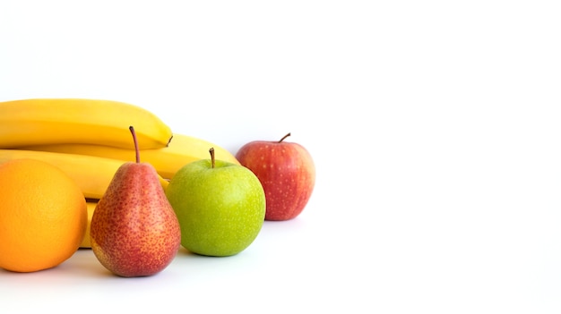 Photo bannière. fruits : banane, orange, pomme et poire, isolés sur une surface blanche. espace de copie.