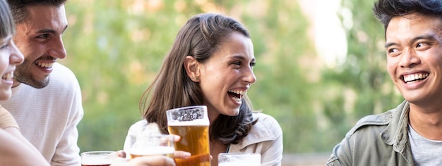 Photo bannière horizontale ou en-tête avec des amis multiraciaux buvant de la bière au pub de la brasserie véritable concept de style de vie d'amitié avec des gars et des filles appréciant l'happy hour focus sur le visage de la fille