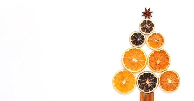 Bannière de Noël avec arbre de Noël composé d'oranges séchées, de bâtons de cannelle et d'anis étoilé.