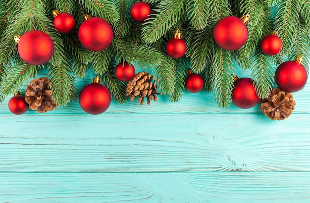 Bannière de Noël avec arbre vert, décorations de boule rouge, cônes sur fond texturé en bois menthe