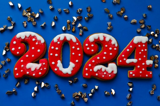 Photo bannière de noël et du nouvel an biscuits au pain d'épice numéros 2024 sur fond bleu avec espace de copie