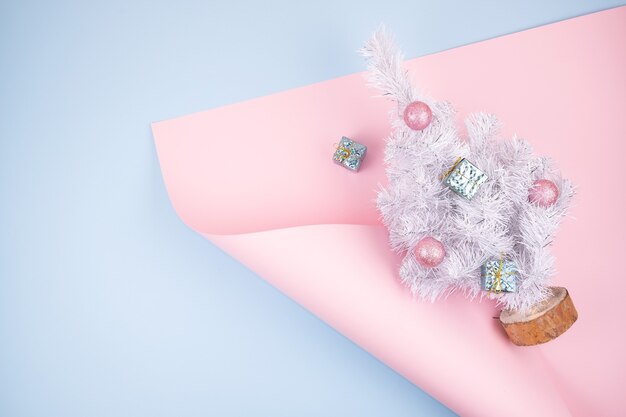 Bannière de noël moderne minimaliste tendance avec sapin de recyclage blanc avec des boules sur rose et bleu