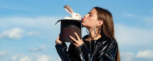 Bannière de Pâques avec femme lapin. Lapin magicien, vêtements élégants. Alice au pays des merveilles. Lapin en peluche. Concept de mode.