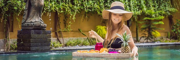 Bannière plateau de petit-déjeuner format long dans la piscine petit-déjeuner flottant dans un hôtel de luxe fille relaxante