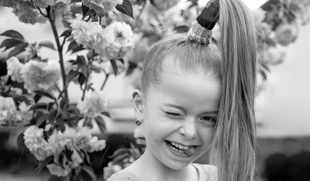 Bannière avec portrait d'enfants de printemps Portraits drôles de printemps magnifique petite fille sur fond de fleur de cerisier