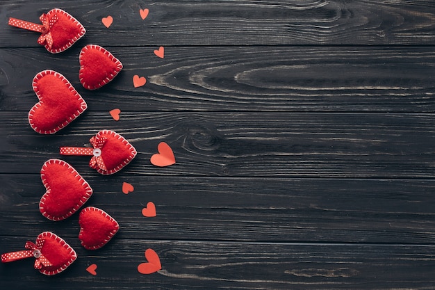 Bannière pour la Saint-Valentin avec des coeurs décoratifs, des bougies et des cadeaux sur un fond en bois sombre