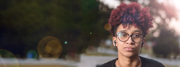 Bannière sérieuse jeune femme latine regardant la caméra à l'extérieur au coucher du soleil avec espace de copie