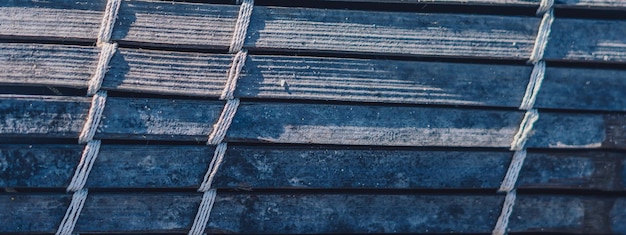 BANNIÈRE Vieux tapis en bambou tissé texture rugueuse bannière de fragment sale Lignes verticales horizontales diagonales ombre de contraste Copier l'espace pour le texte Arrière-plan abstrait Tons gris bleu foncé clair plus de stock