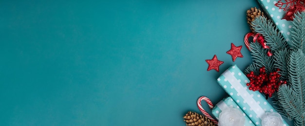 Bannière de voeux de Noël avec des décorations de vacances d'hiver à plat sur fond turquoise avec espace de copie