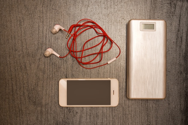 Banque d'alimentation, smartphone et casque sur un tableau noir. Vue de dessus