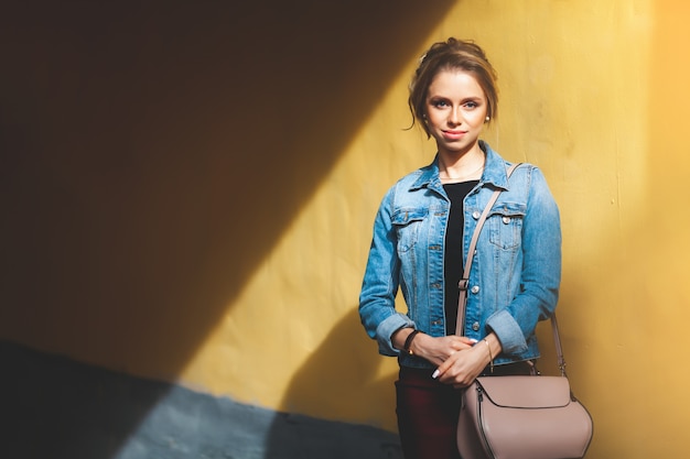 Banque d'images - Jeune fille séduisante avec du maquillage en veste de jeans dans la rue à l'été