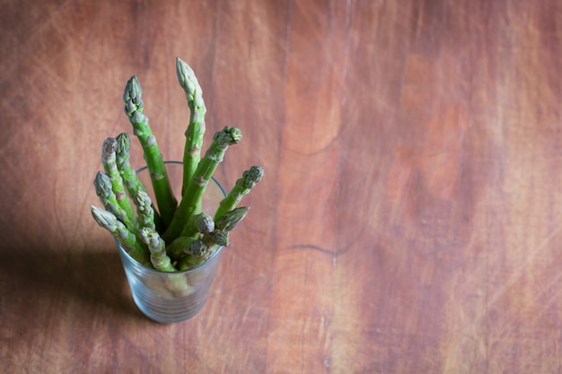 Banques d'asperges vertes fraîches sur fond de bois