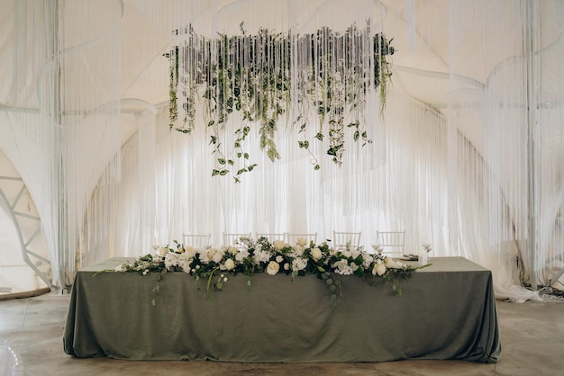 Banquet de mariage Les chaises et la table ronde pour les invités servies avec des fleurs de coutellerie et de la vaisselle et recouvertes d'une nappe