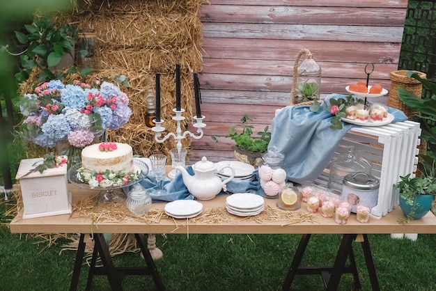 Bar à bonbons de mariage de style rustique décoré d'assiettes couverts verres