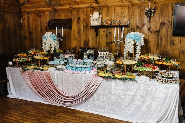 Bar à bonbons Table de fête avec bonbons bonbons desserts tartelette aux framboises et cupcakes réception de mariage tartelettes