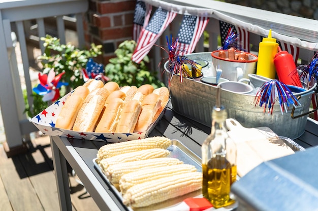 Photo bar à hot-dogs avec épis de maïs pour la célébration du 4 juillet sur la terrasse arrière.