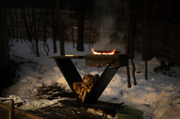 Barbecue au feu de bois avec flamme brûlante le soir