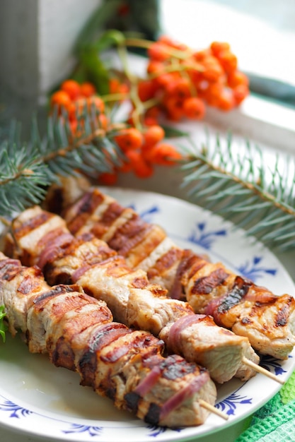 Barbecue juteux sur le gril sur un arrière-plan flou Morceaux de shashlik sur la brochette rôtis sur le gril se bouchent