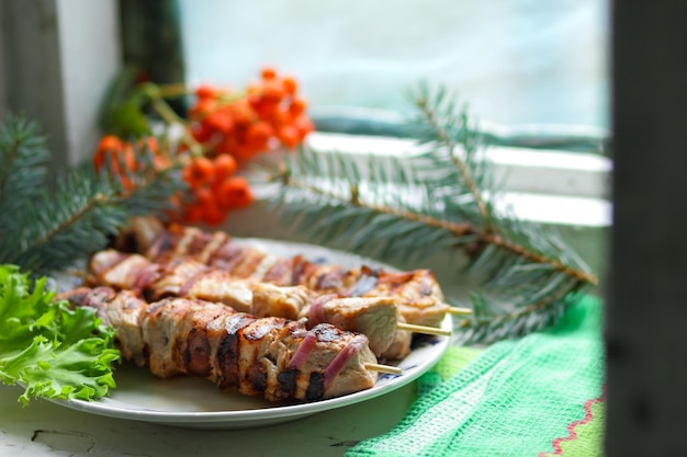 Barbecue juteux sur le gril sur un arrière-plan flou Morceaux de shashlik sur la brochette rôtis sur le gril se bouchent