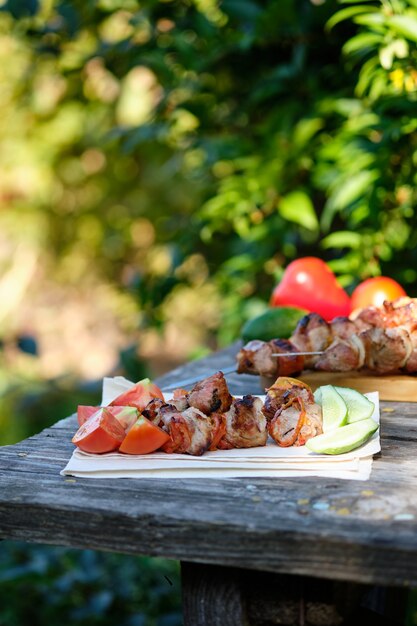 Barbecue et légumes fraîchement cuits sur une table en bois. Déjeuner d'été dans la nature.