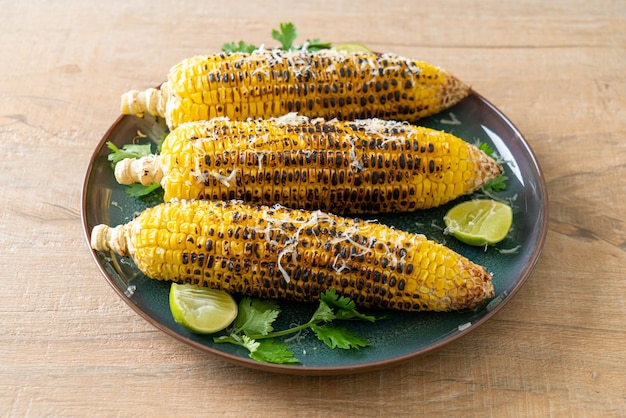 barbecue et maïs grillé avec fromage et citron vert sur assiette