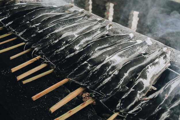 Barbecue de poissons-chats grillés sur un poêle à charbon chaud de manière traditionnelle à Yogyakarta en Indonésie ou normalement appelé Mangut lele