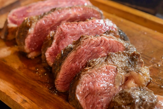 Barbecue de viande rôtie et tranchée sur planche de bois avec arrière-plan flou Brésil