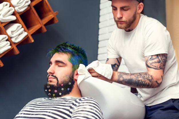 Barber essuyant la tête de son client avec une serviette