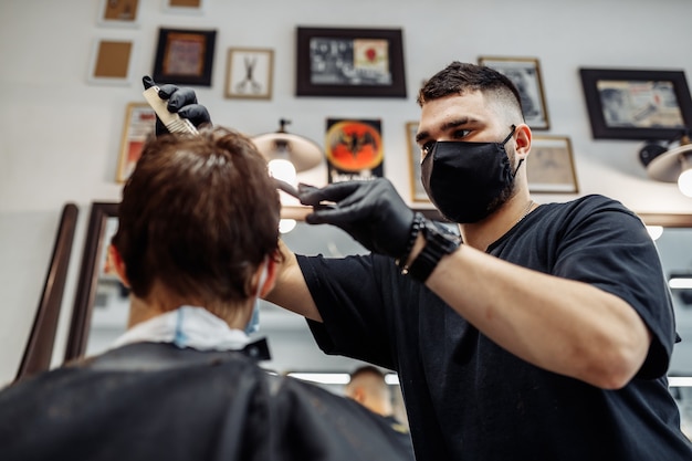 Barber fait une coupe de cheveux et une coiffure dans un salon de coiffure, un salon de beauté. Des cheveux sains.