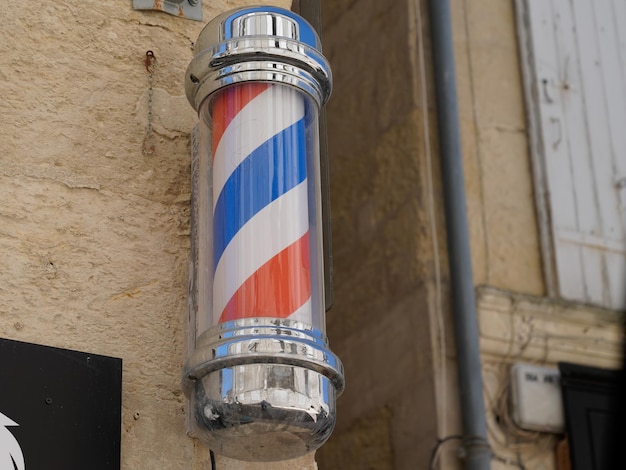 Barber pole shop pancarte signe cylindrique dans le salon de coiffure vintage mur blanc rouge bleu couleurs