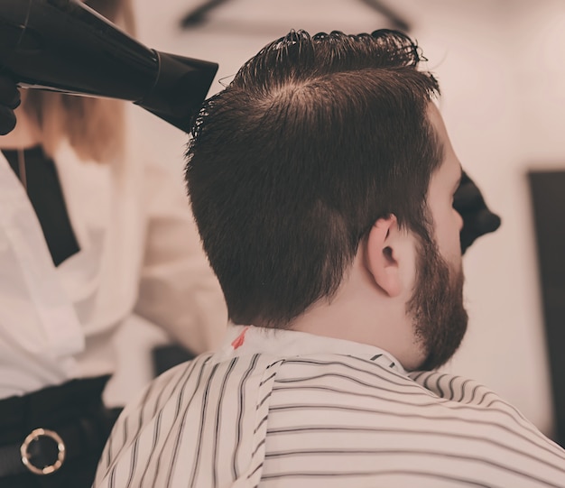 Barber sèche les cheveux d'un homme