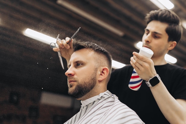 Barber tonte barbe à l'homme dans un salon de coiffure cadrage délié rasoir électrique teinté brun vintage