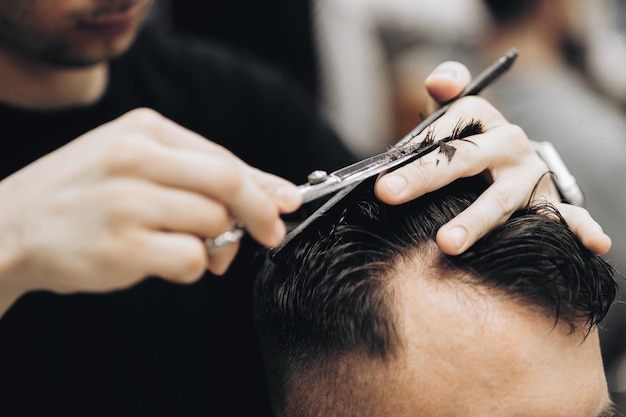 Barber tonte barbe à l'homme dans un salon de coiffure cadrage délié rasoir électrique teinté brun vintage