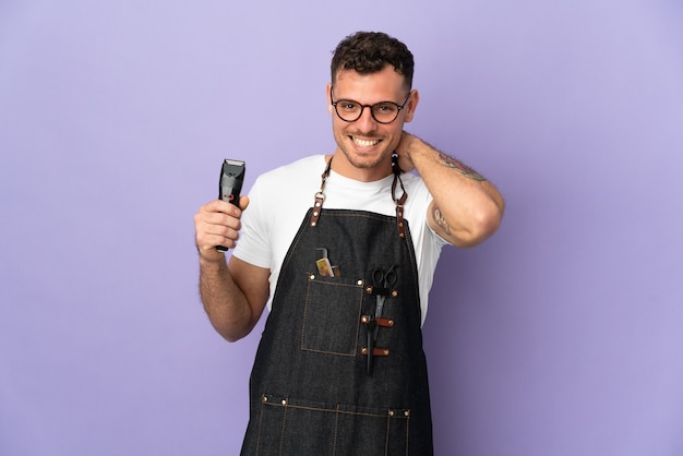 Barbier homme caucasien dans un tablier sur violet en riant