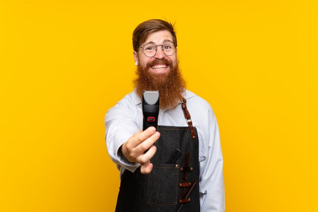 Barbier avec une longue barbe dans un tablier sur fond jaune isolé