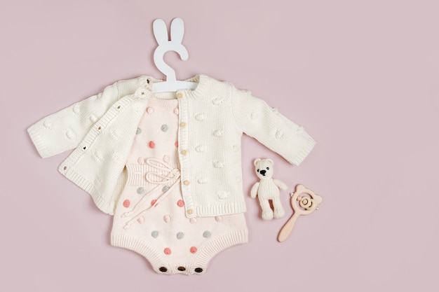 Barboteuse en tricot pastel avec pull, chaussons et tétine. Ensemble mignon de vêtements de bébé