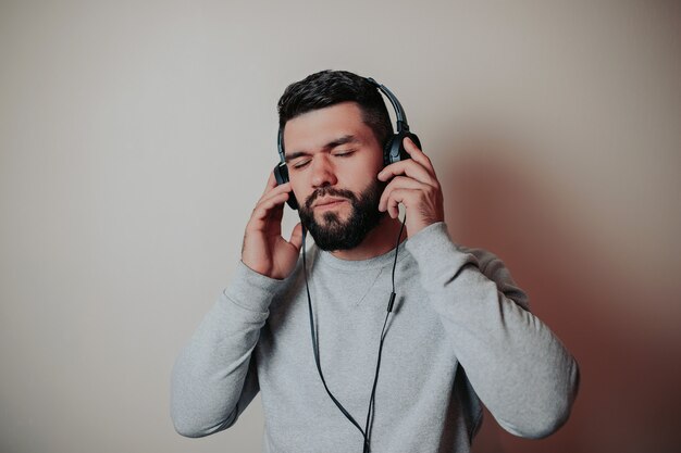 Barbu bel homme dans les écouteurs, homme écoute de la musique,